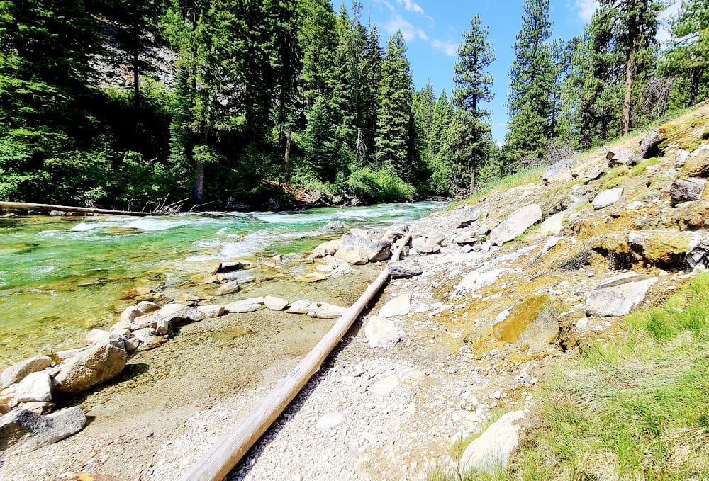 green hot spring pools at the edge of a river