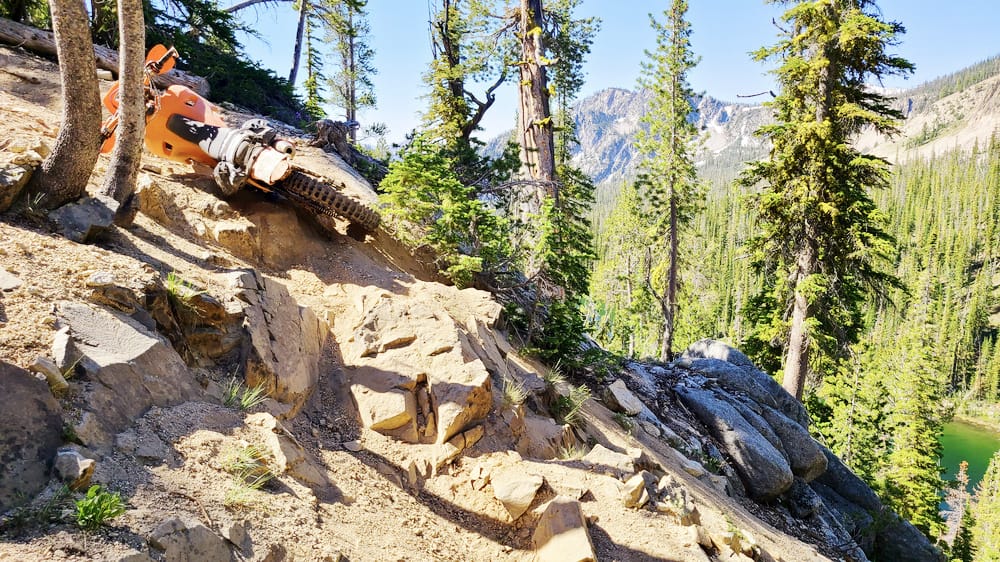 motorcycle on its side next to a steep ravine