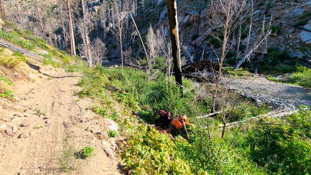 motorcycle in bushes off the trail in riverbed