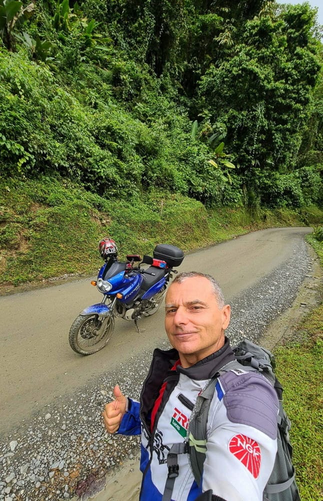 selfie with a motorcycle on a road going through a jungle 