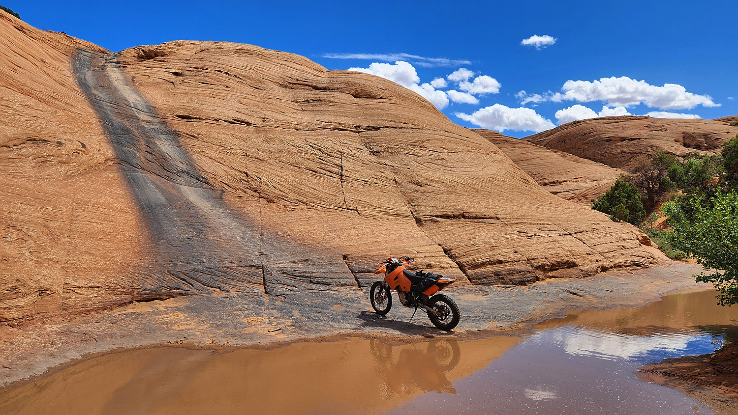 motorcycle parked at the base of steep climb up a rock face