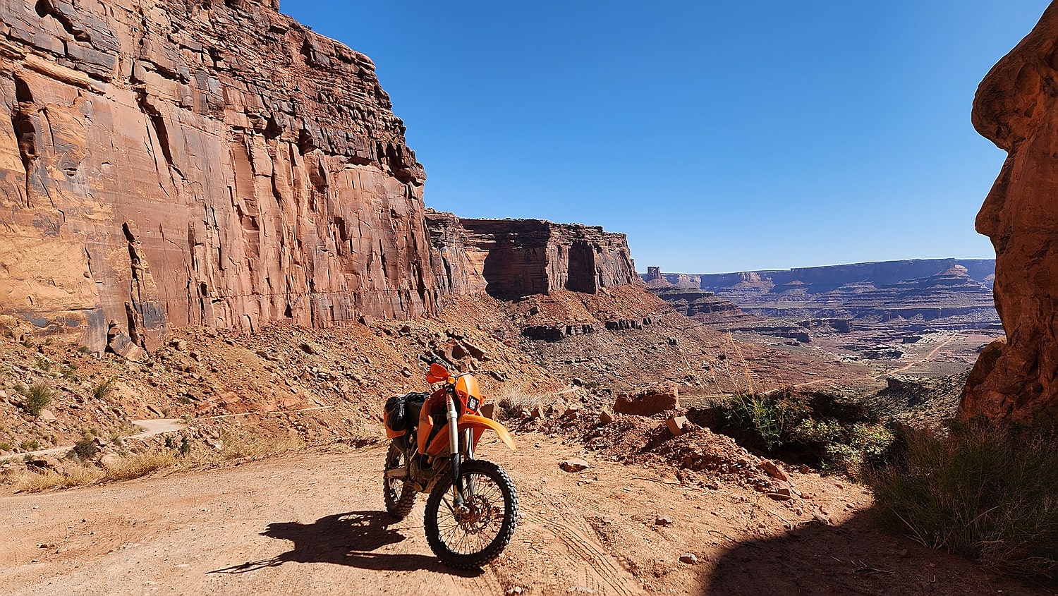 motorcycle parked on a dirt trail surrounded by steep rock walls