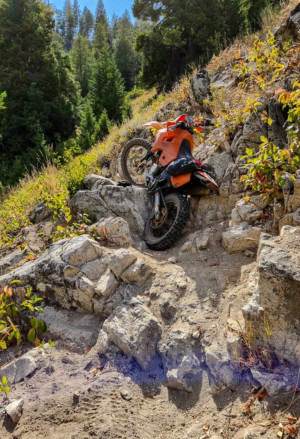 motorcycle on rocky steps on an exposed trail