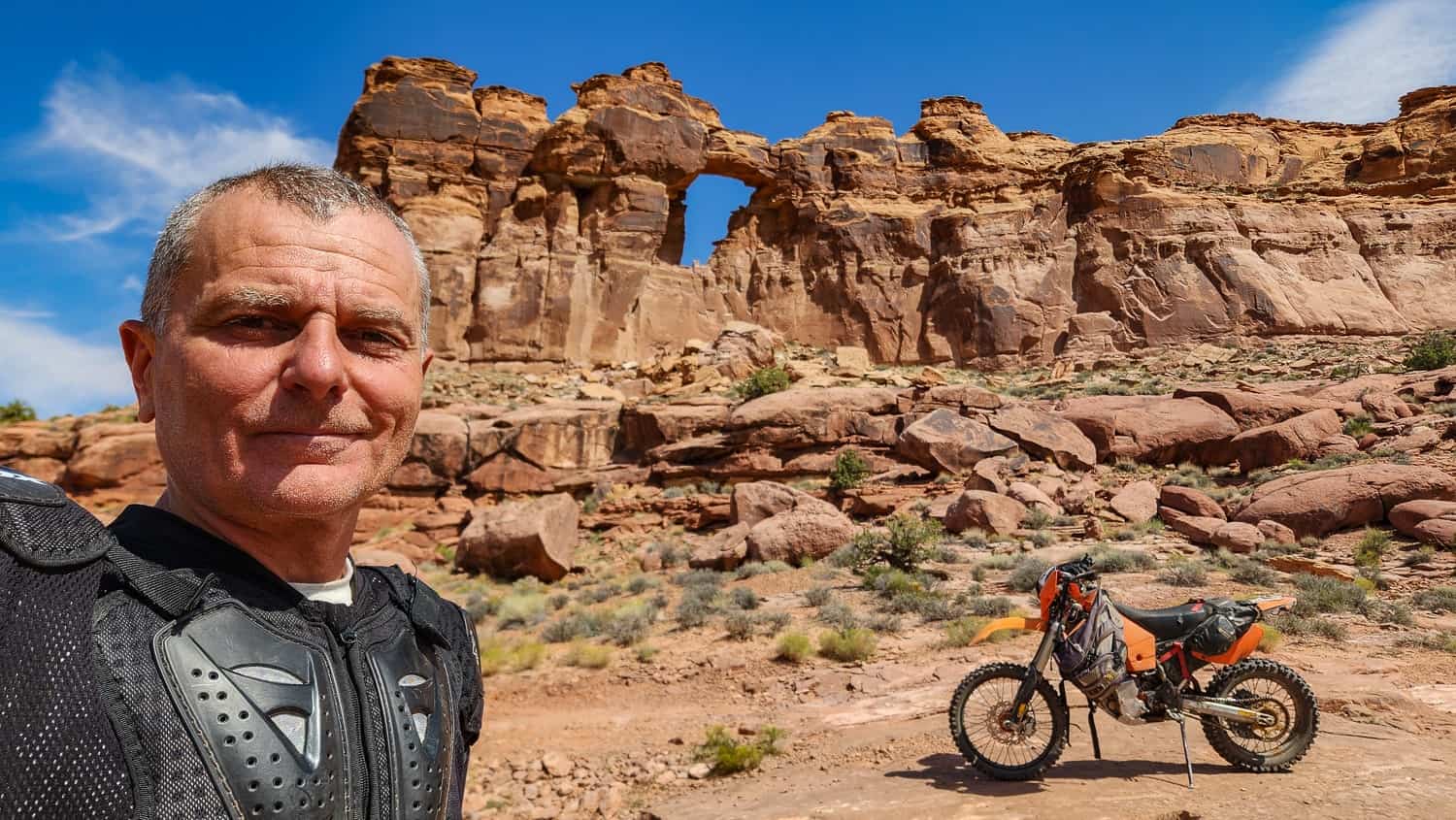 rider and motorcycle with an arch behind