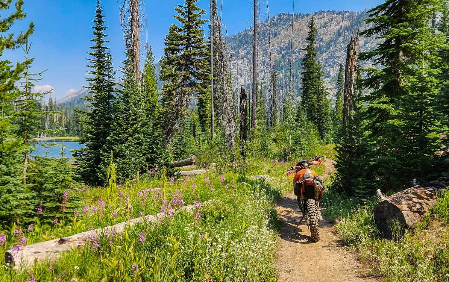 motorcycle on a trail next to an alpine lake