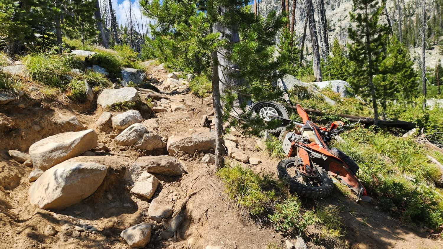 motorcycle on the ground next to large boulders