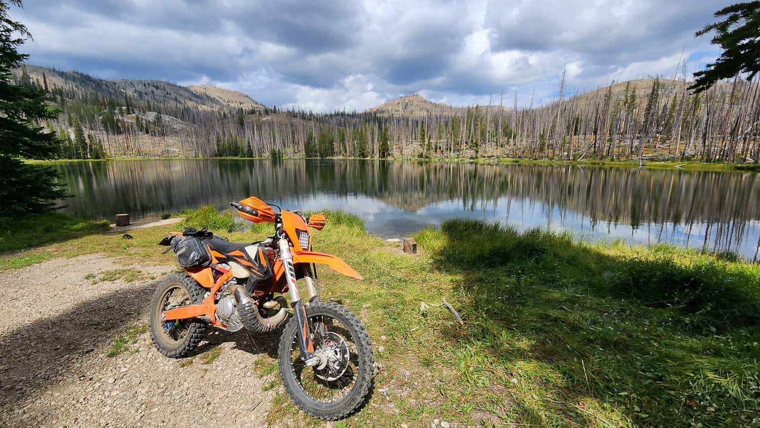 motorcycle parked next to an alpine lake