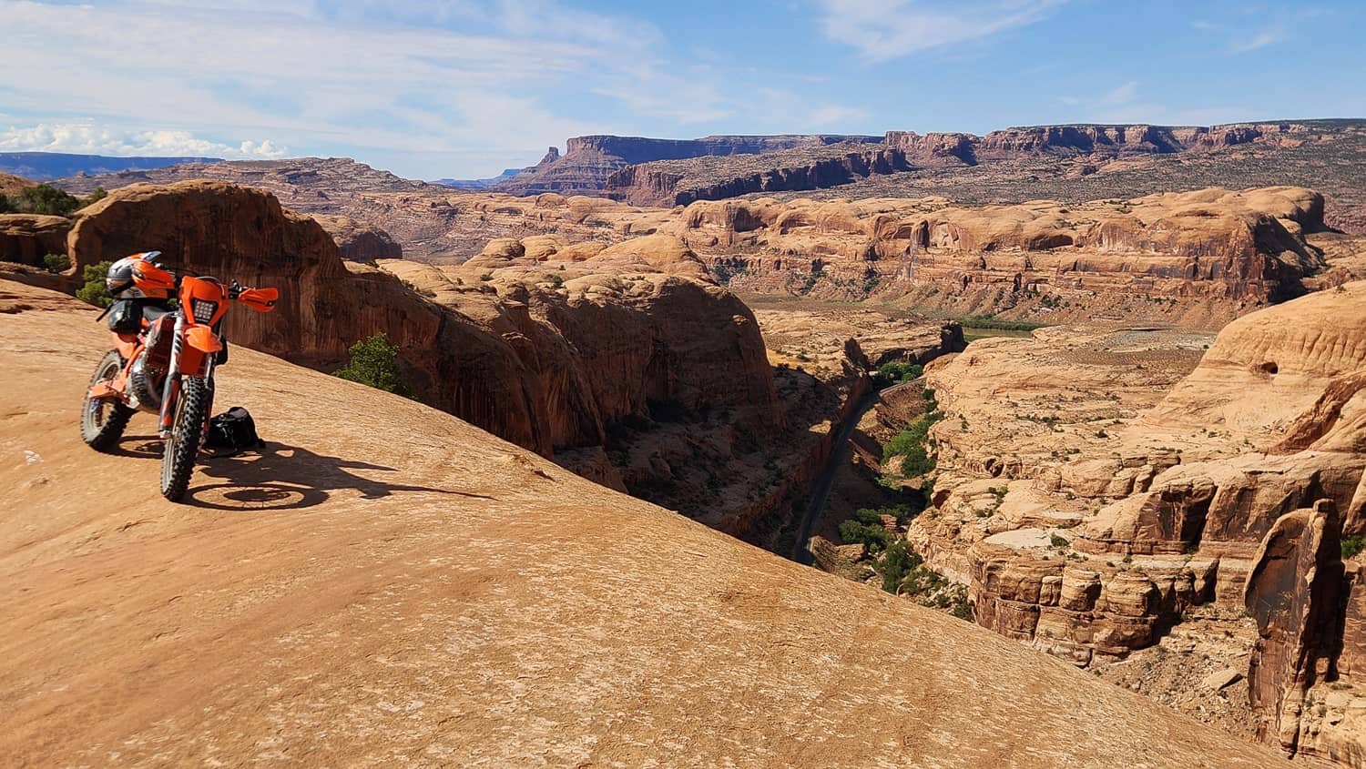 motorcycle parked high above a narrow canyon with red cliffs behind