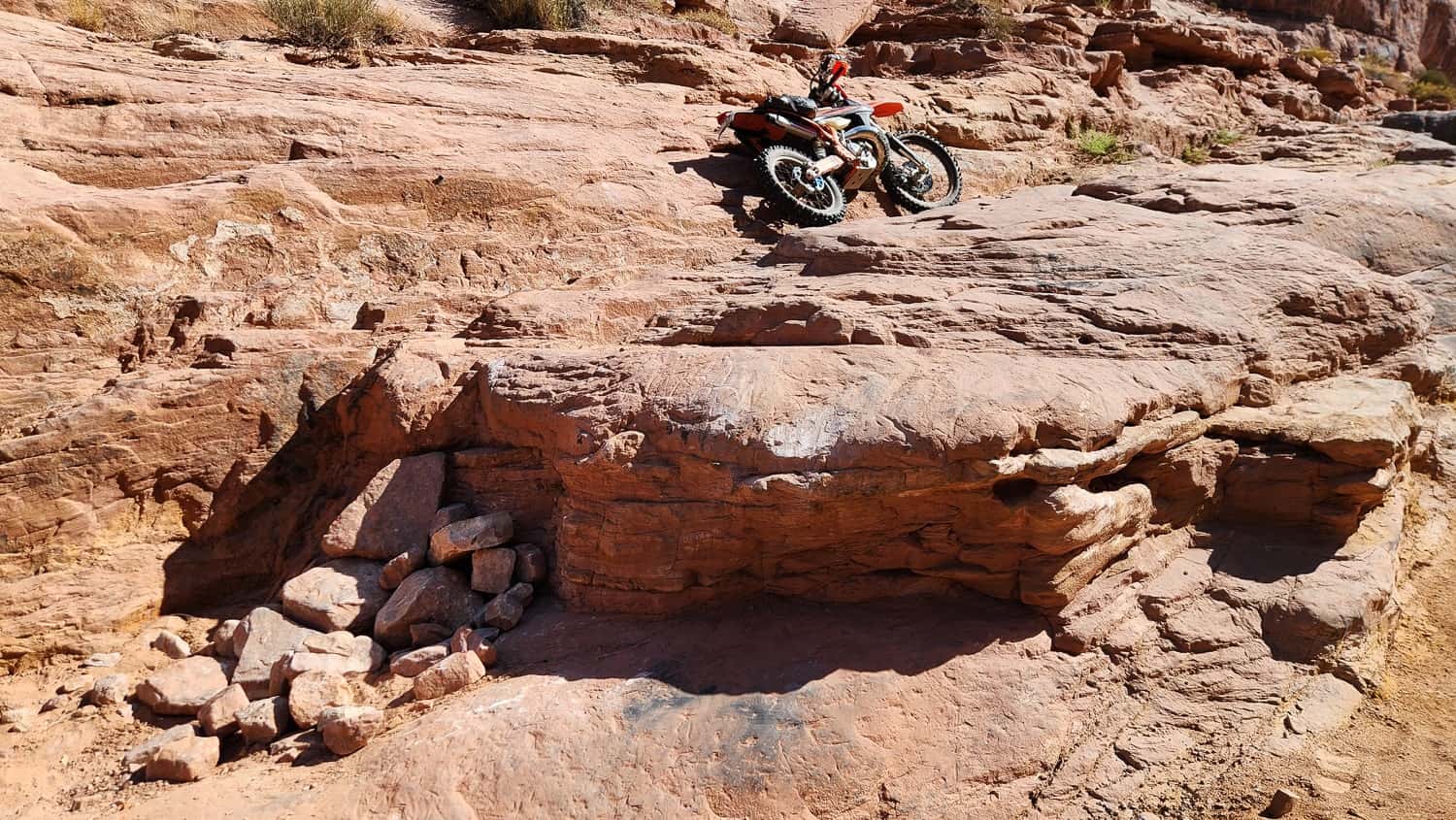 motorcycle parked atop a big rock step