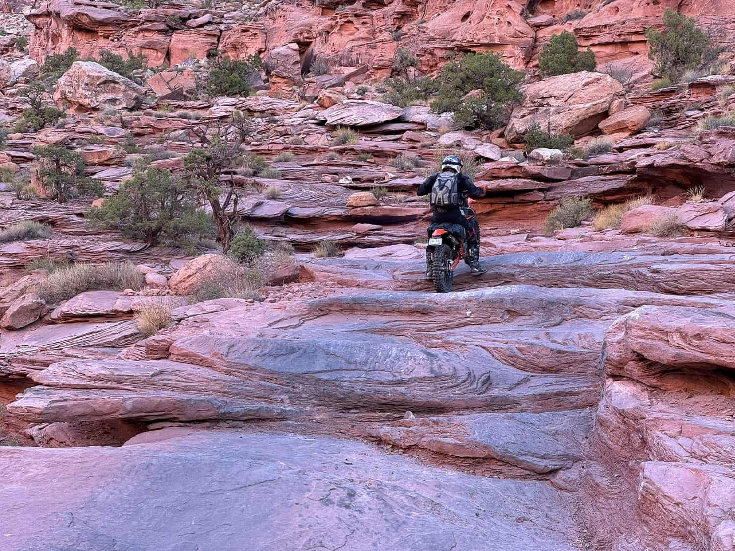 rider on a motorcycle climbing up rock steps