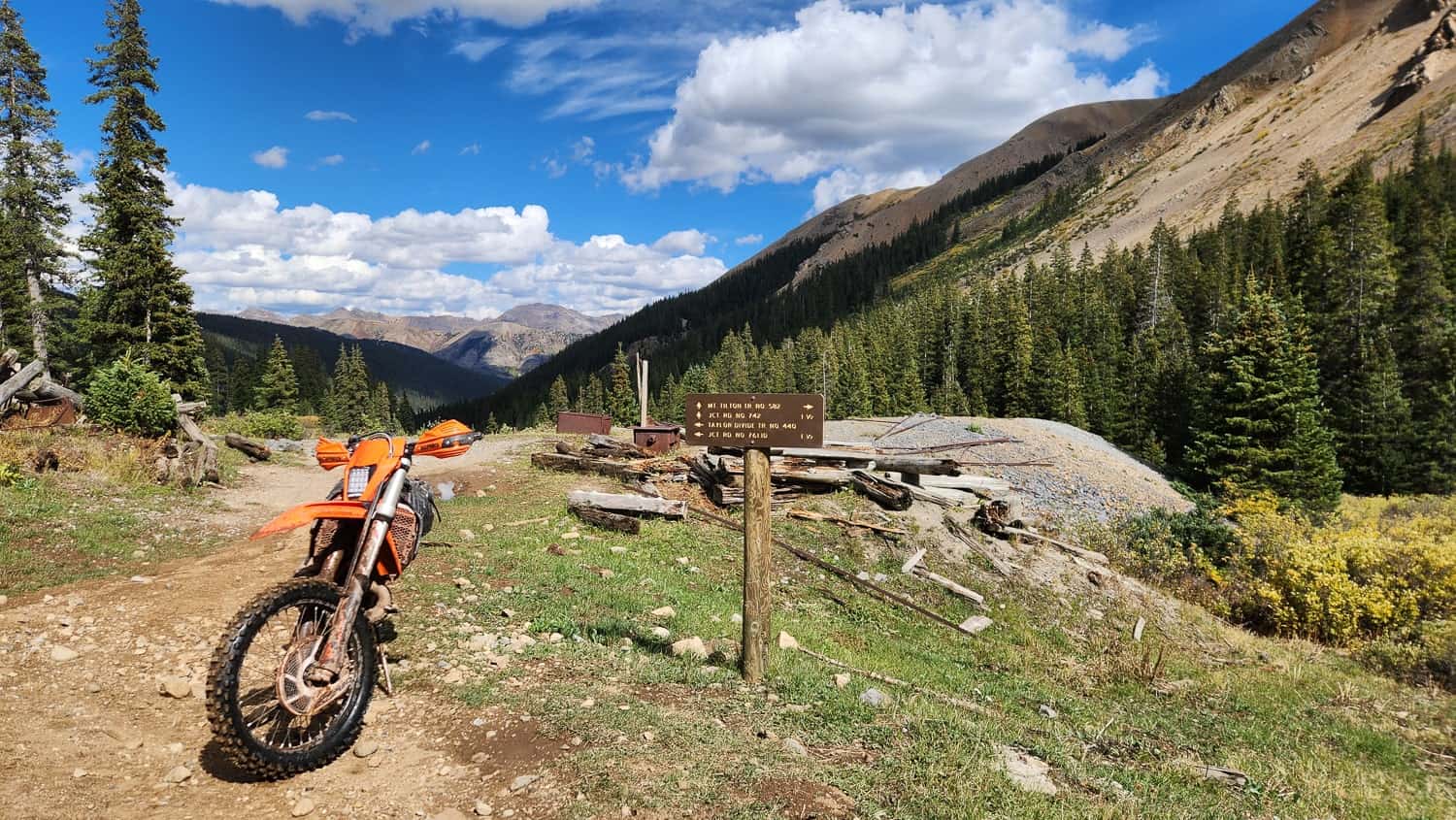 motorcycle parked next to a trail sign