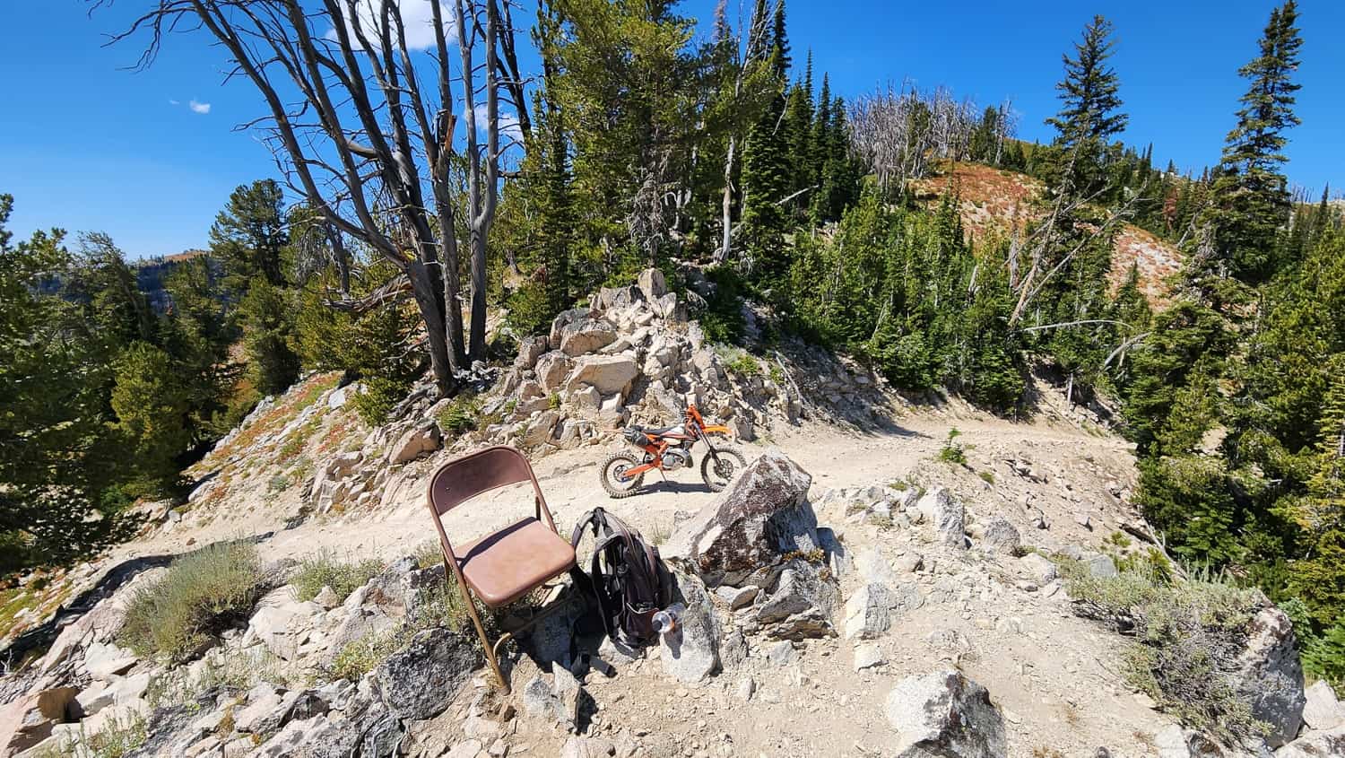 classroom chair on a pile of rocks and motorcycle behind
