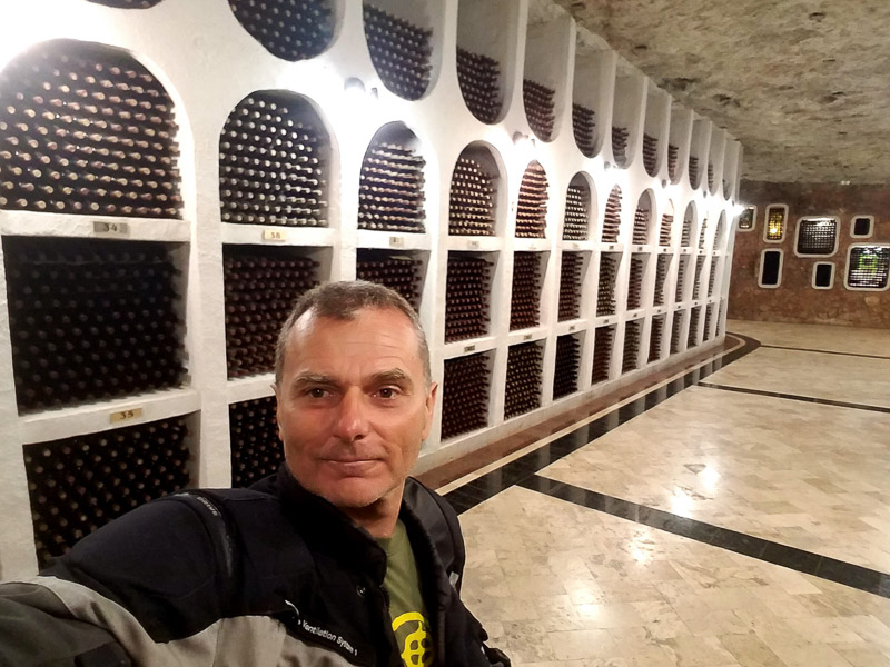 selfie with countless wine bottles stored behind