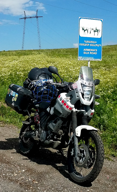 motorcycle parked next to a street sign