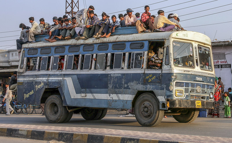 an old bus full of people and roof full of people