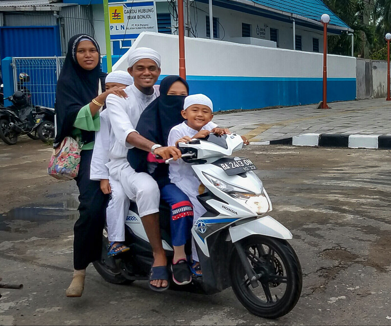two adults and three kids on a scooter