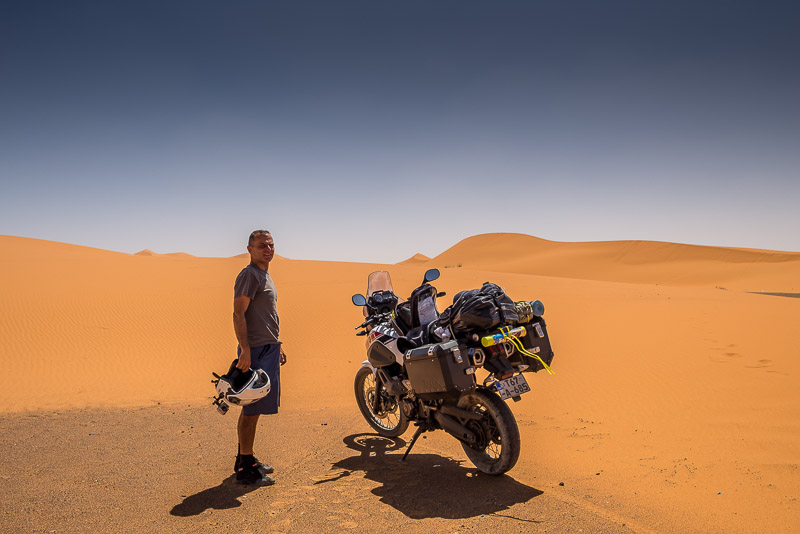 Posing with motorcycle in front of sand dunes