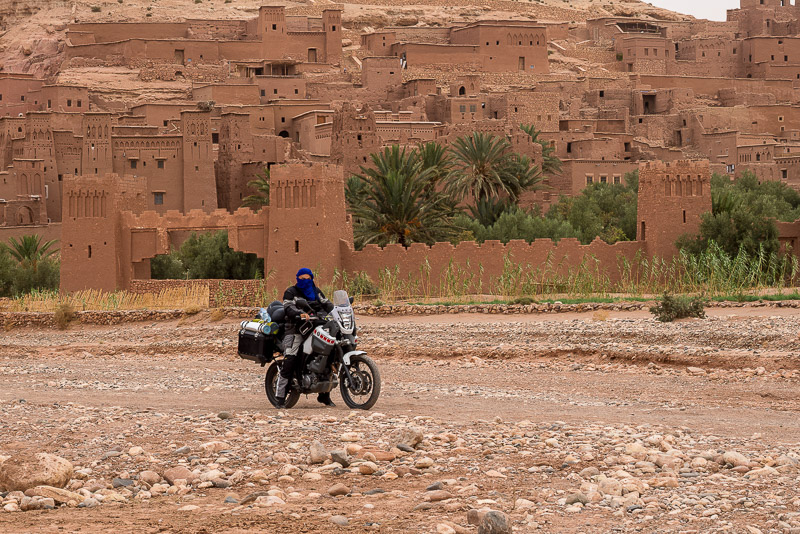 On a motorcycle in front of a walled city