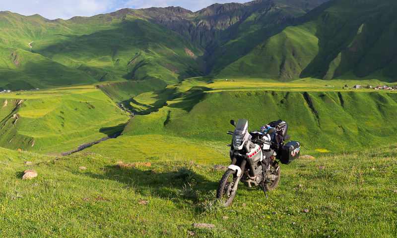 motorcycle parked with green gass covered hills behind