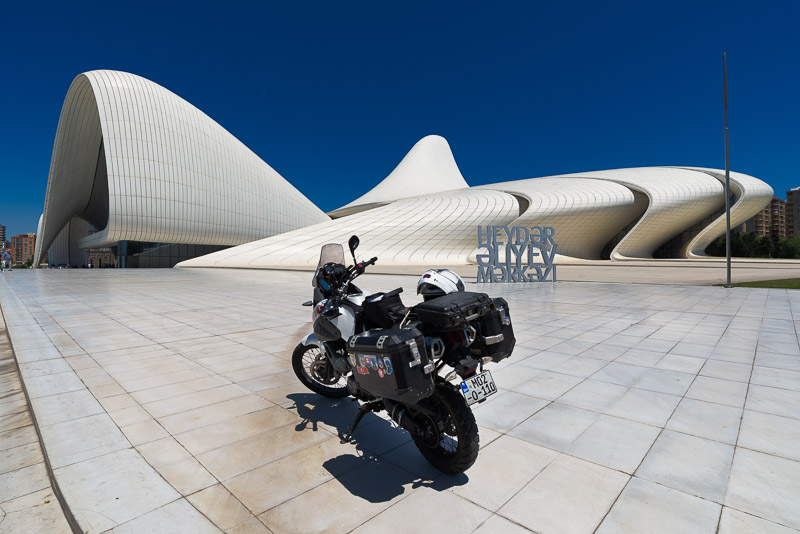 motorcycle parked in front of a conetmporary design white building