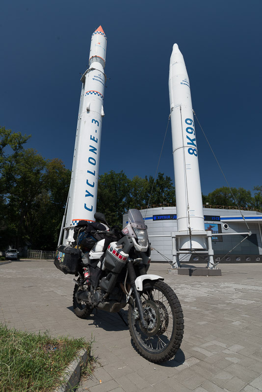 motorcycle parked in front of two rockets