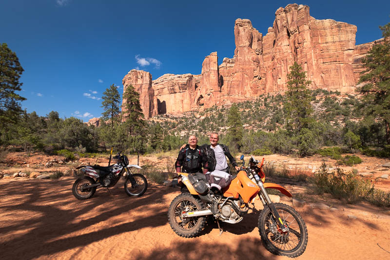 motorcycle riders posign in front of rock walls