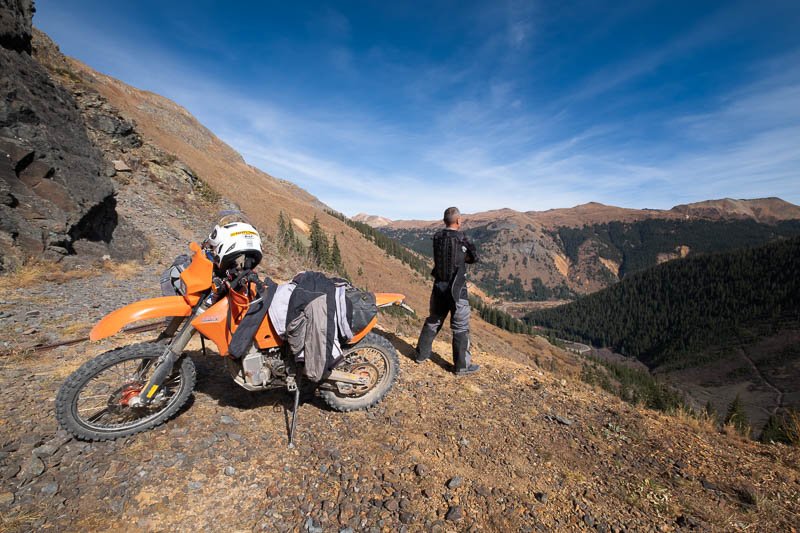 rider looking over a vaelley below into the distant peaks