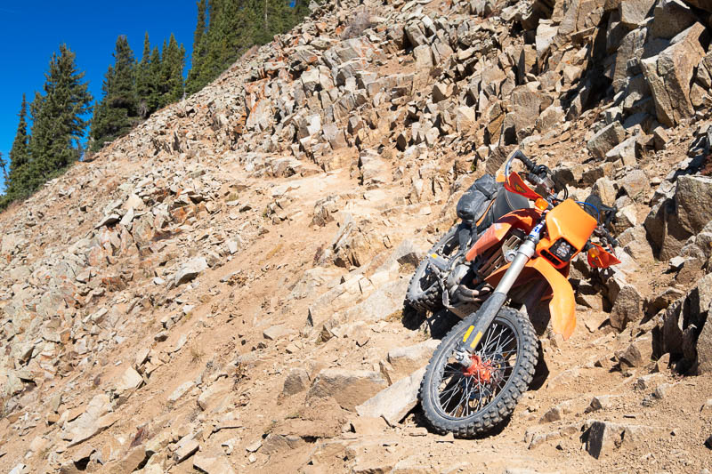 Motorcycle laying on a side of a steep hill