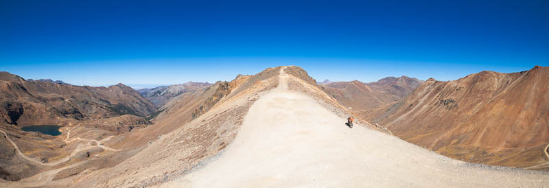 sweeping view of an alpine pass and a motorcycle