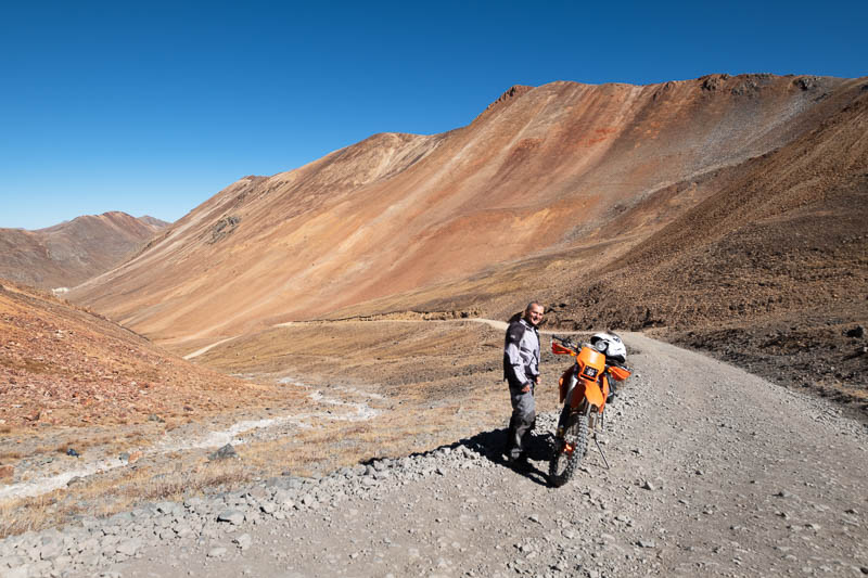 motorcycle and rider with a red mountain behind