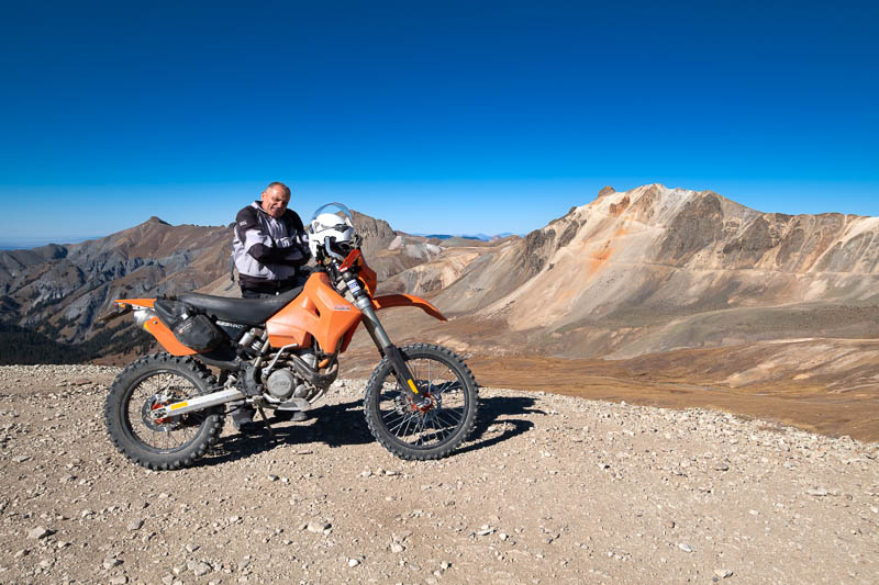 motorcycle and rider with red-yellow mountain behind
