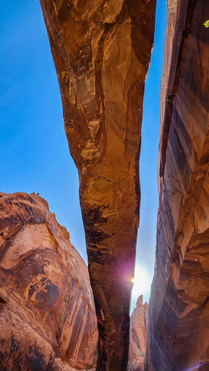 the sun peeking from behind an arch 