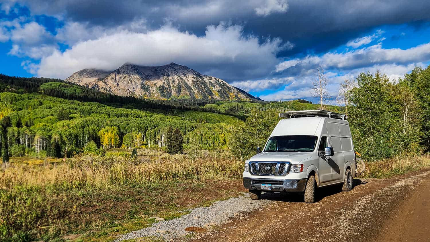 van parked with mountain peak covered by a cloud