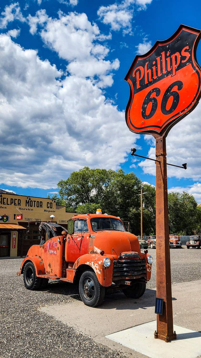 an old truck next to a sign 