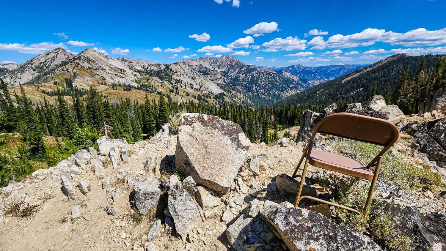 a school chair atop a pile of rocks in the mountains 