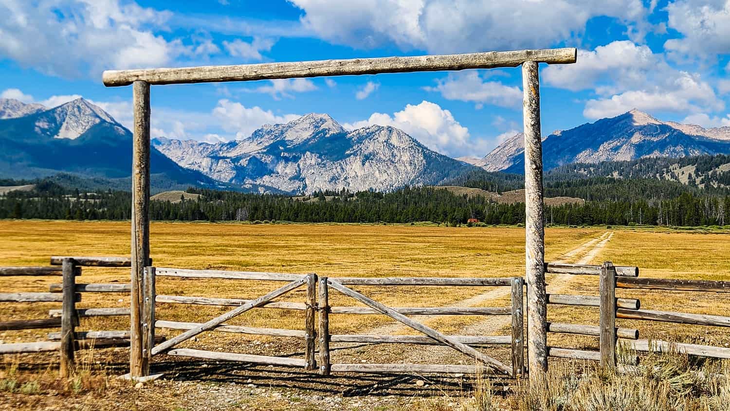 ranch gate with granite peaks behind