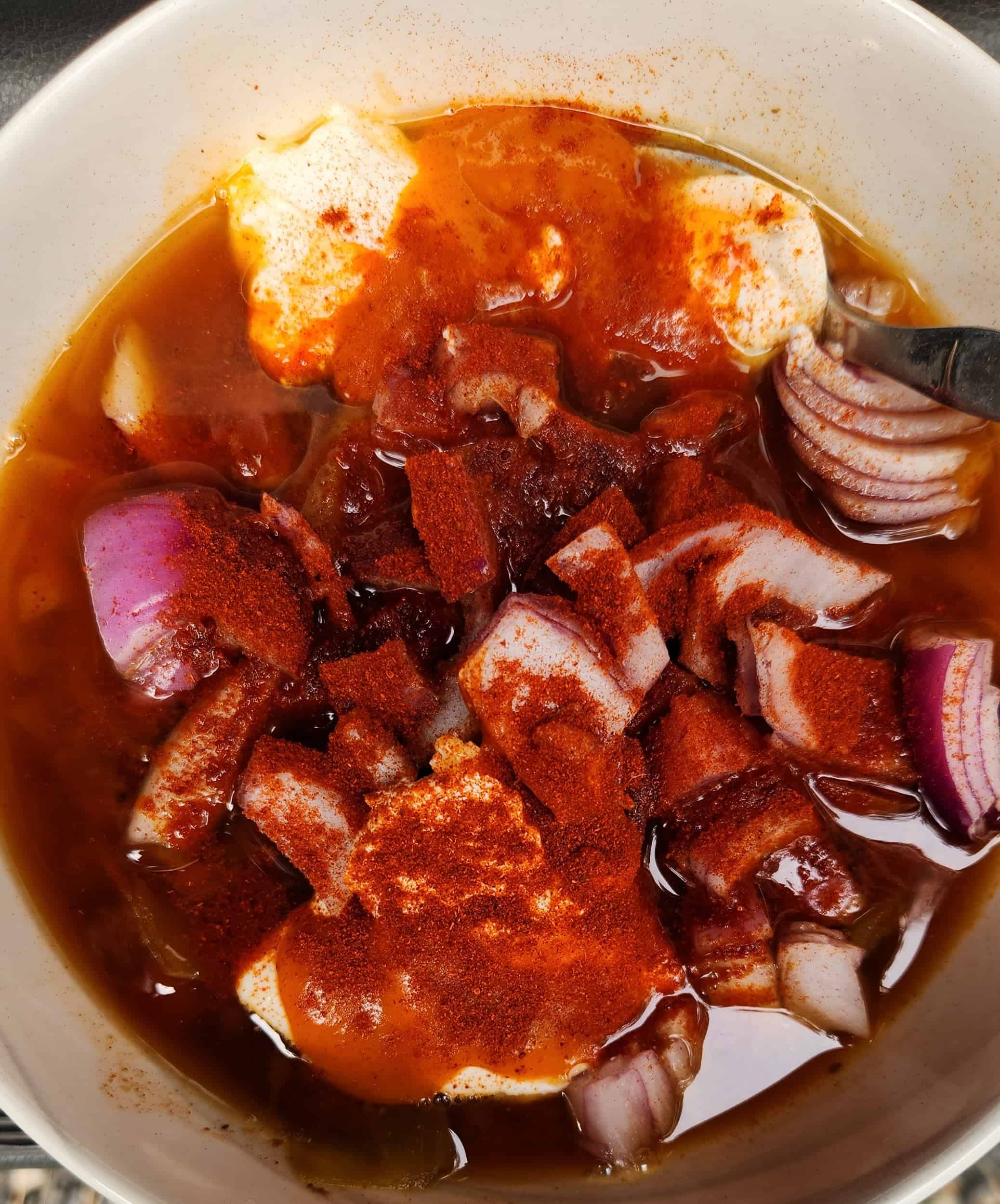 a bowl of soup with chopped onions, sour cream and red pepper powder 